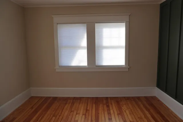 a view of a room with wooden floor and a window