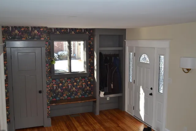 a view of a hallway with wooden floor and a living room
