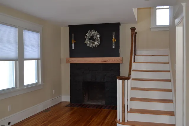 a view of a hallway with wooden floor and a fireplace