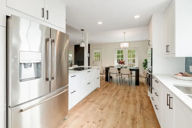 a kitchen with refrigerator a sink and chairs