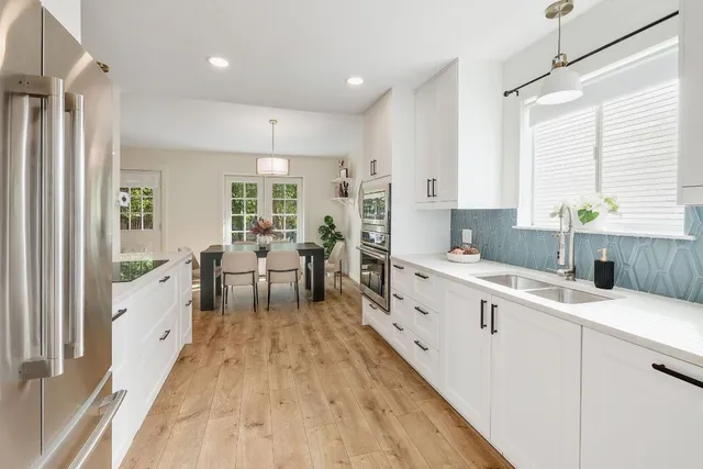 a large white kitchen with sink and white cabinets