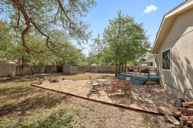 a view of a backyard that has a tree on the side