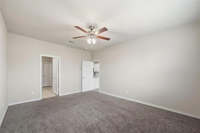 an empty room with a fan and a window