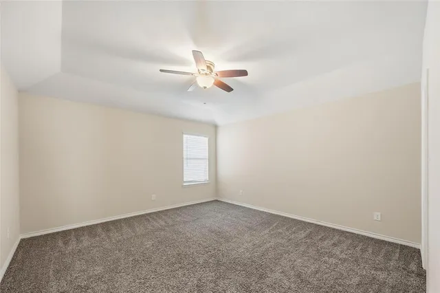 an empty room with a window and a ceiling fan