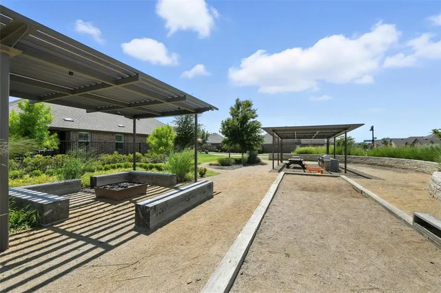 a view of a patio with table and chairs under an umbrella with a fire pit
