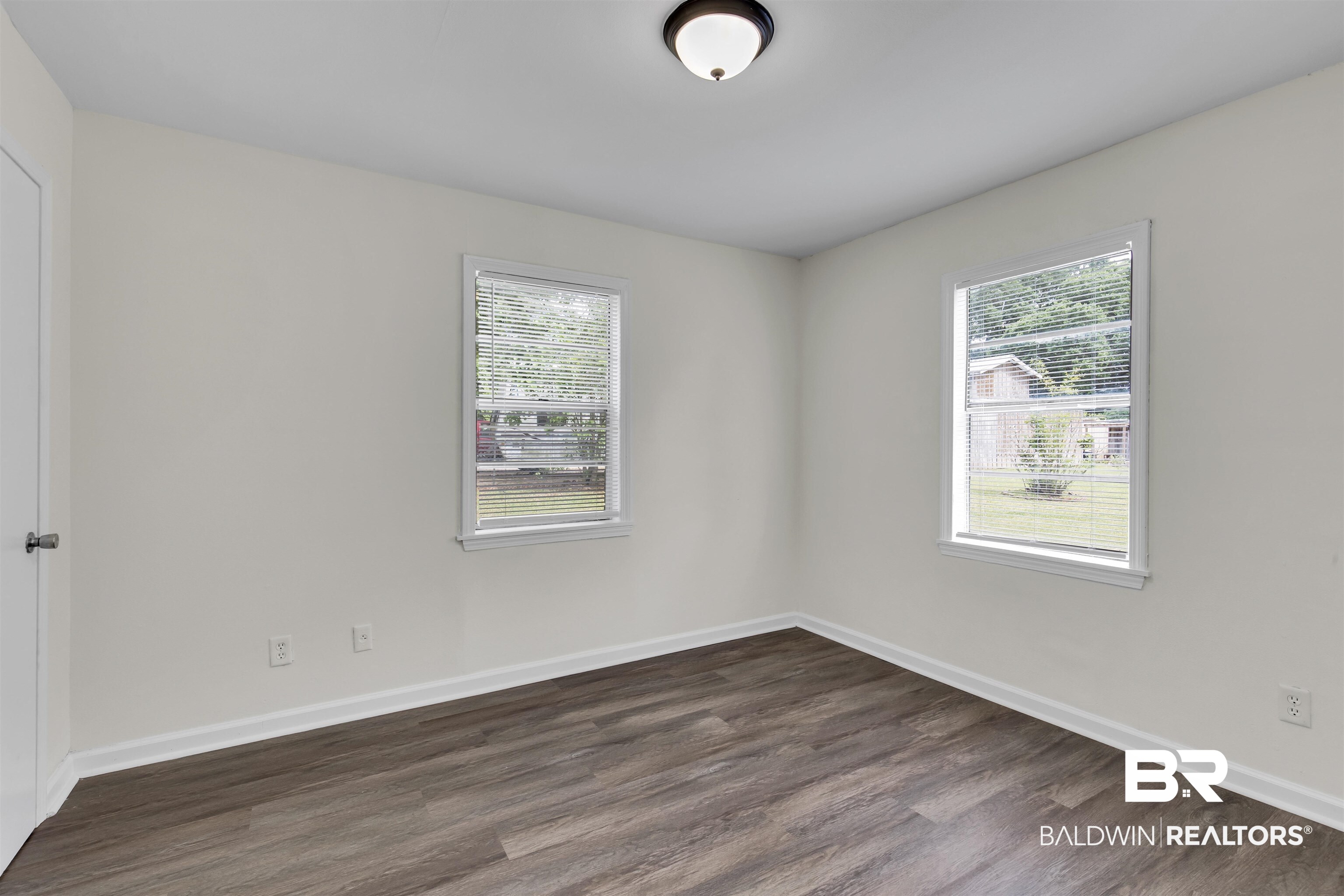 9241 Vallaris Street North Mobile, AL 36608 - Photo 6 of 17 Empty room with baseboards, dark wood-type flooring, and plenty of natural light