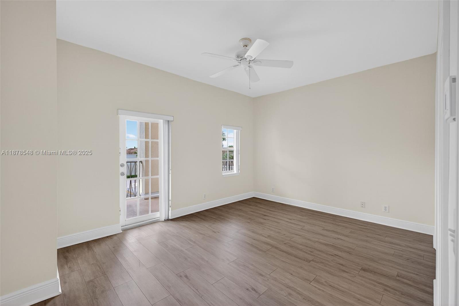 27 Southwest 6th Court Pompano Beach, FL 33060 - Photo 19 of 70 a view of an empty room with wooden floor and a window
