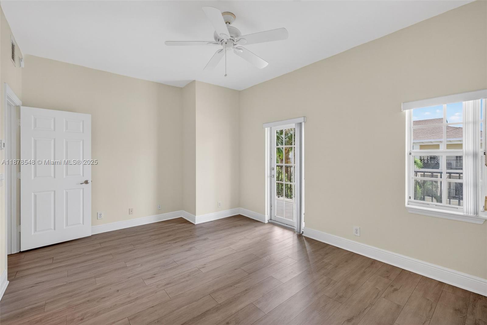 27 Southwest 6th Court Pompano Beach, FL 33060 - Photo 20 of 70 an empty room with wooden floor chandelier fan and windows