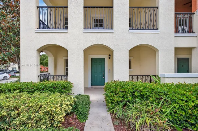 a front view of a building with cars parked on road