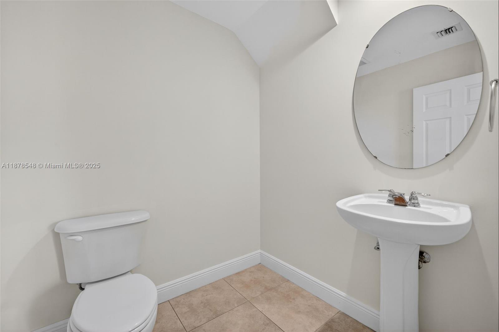 27 Southwest 6th Court Pompano Beach, FL 33060 - Photo 46 of 70 a bathroom with a toilet a sink and mirror