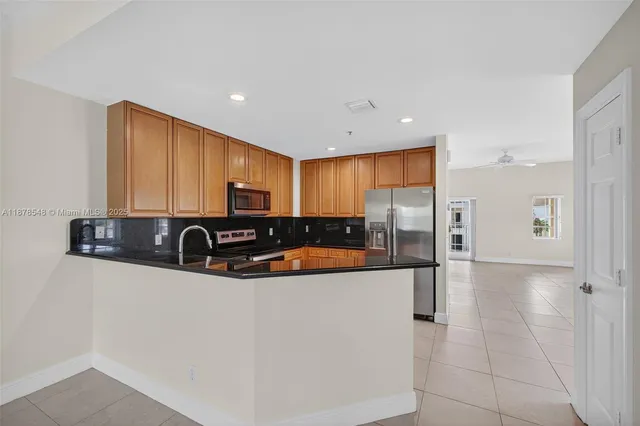 a kitchen with stainless steel appliances granite countertop a sink a refrigerator and a stove
