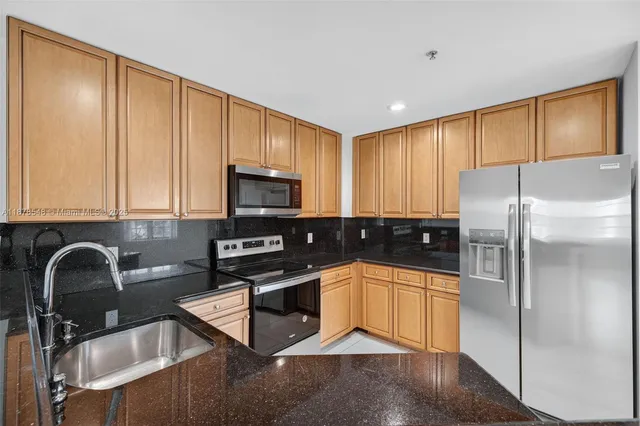 a view of a kitchen with a sink and a refrigerator