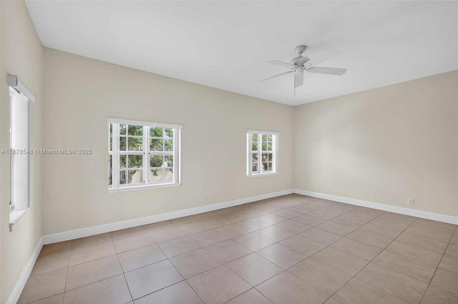 27 Southwest 6th Court Pompano Beach, FL 33060 - Photo 10 of 70 an empty room with chandelier fan and windows