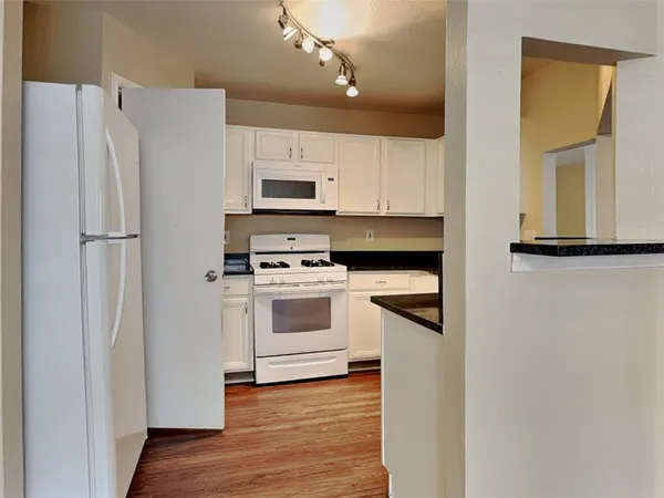 a kitchen with white cabinets and white appliances