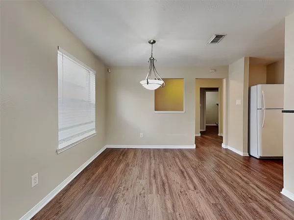 a view of empty room with wooden floor and window
