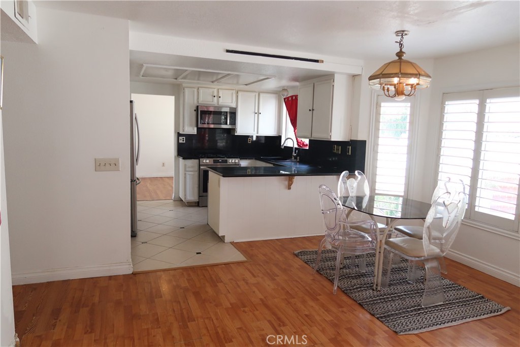 628 Pantera Drive Diamond Bar, CA 91765 - Photo 3 of 8 a kitchen with stainless steel appliances granite countertop a stove top oven a sink a dining table and chairs