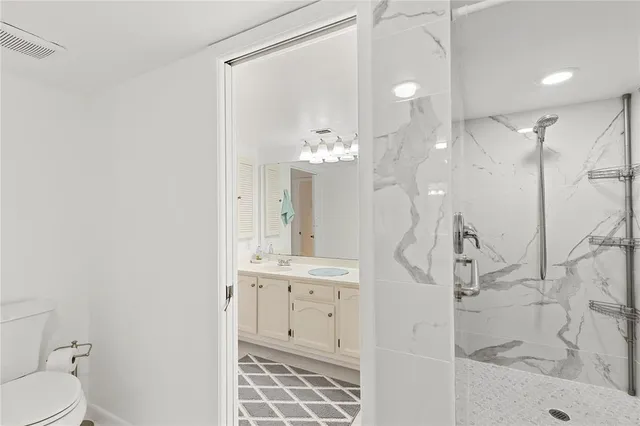 a bathroom with a tub a sink double vanity and mirrors