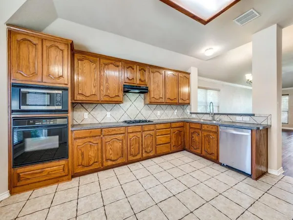 a kitchen with stainless steel appliances granite countertop a stove a sink and a microwave