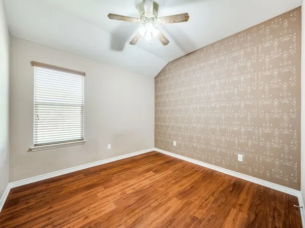 an empty room with a window and wooden floor