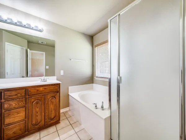a bathroom with a tub sink and mirror