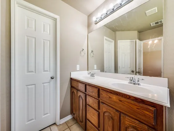 a bathroom with a double vanity sink and a mirror