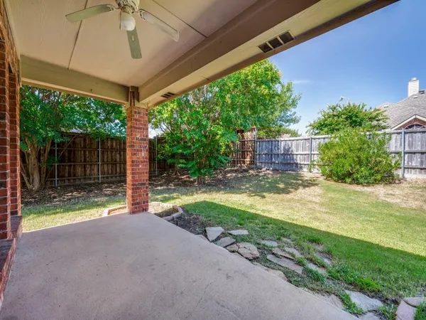 a view of a backyard with plants and a patio