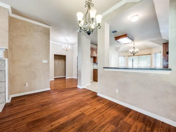 a view of a livingroom with wooden floor and chandelier