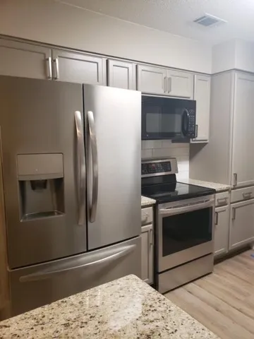 a kitchen with stainless steel appliances a stove a microwave and a refrigerator