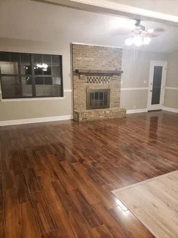 a view of a livingroom with wooden floor and a fireplace