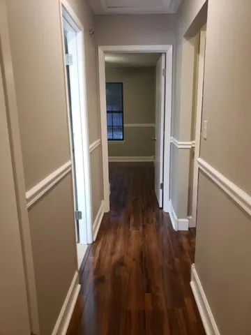 a view of a hallway with wooden floor and staircase