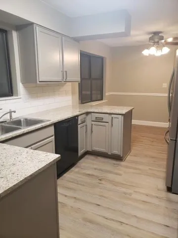 a kitchen with stainless steel appliances granite countertop a sink and a refrigerator