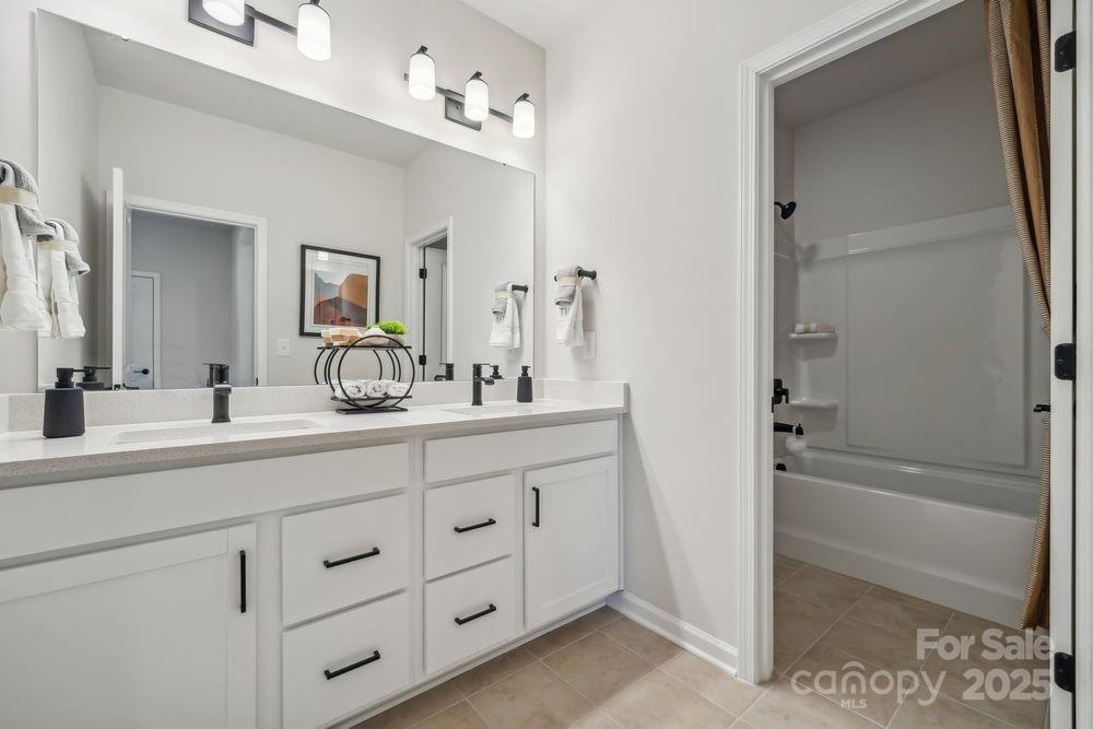 3150 Beacon Hts Road Indian Land, SC 29707 - Photo 20 of 28 a bathroom with a double vanity sink a mirror and a bathtub