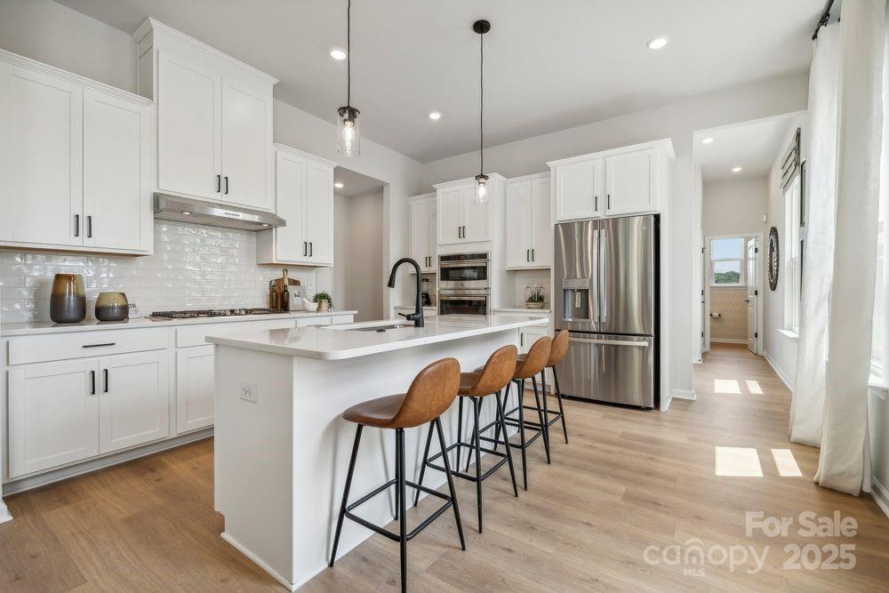 3150 Beacon Hts Road Indian Land, SC 29707 - Photo 6 of 28 a kitchen with stainless steel appliances a refrigerator a sink a stove a dining table and chairs