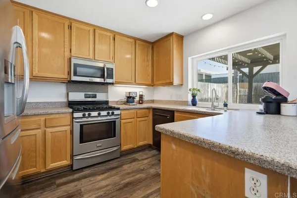 a kitchen with stainless steel appliances granite countertop a stove a sink and a microwave