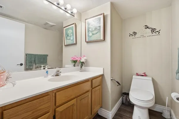 a bathroom with a sink mirror vanity and toilet