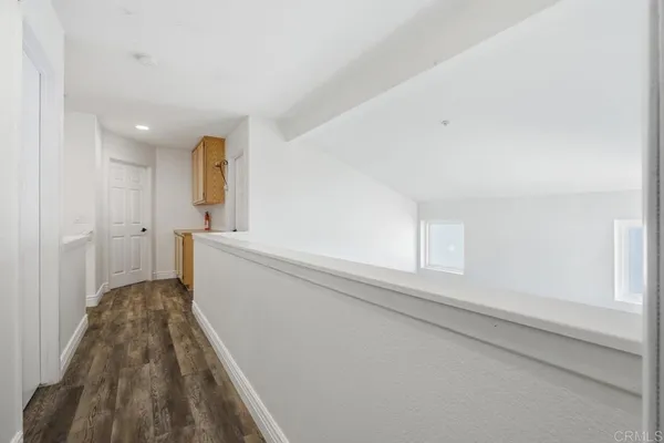 a view of a kitchen with wooden floor and electronic appliances