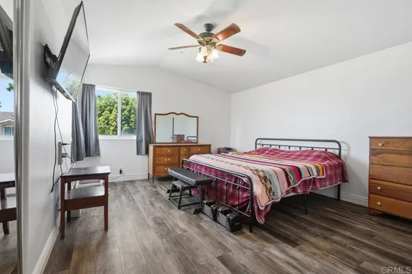 a spacious bedroom with a bed a chandelier and a large window