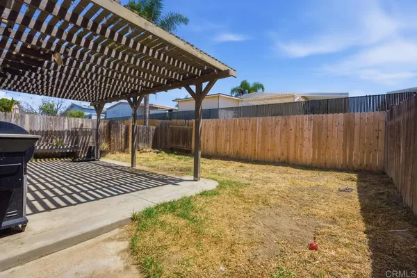 a view of backyard with wooden fence