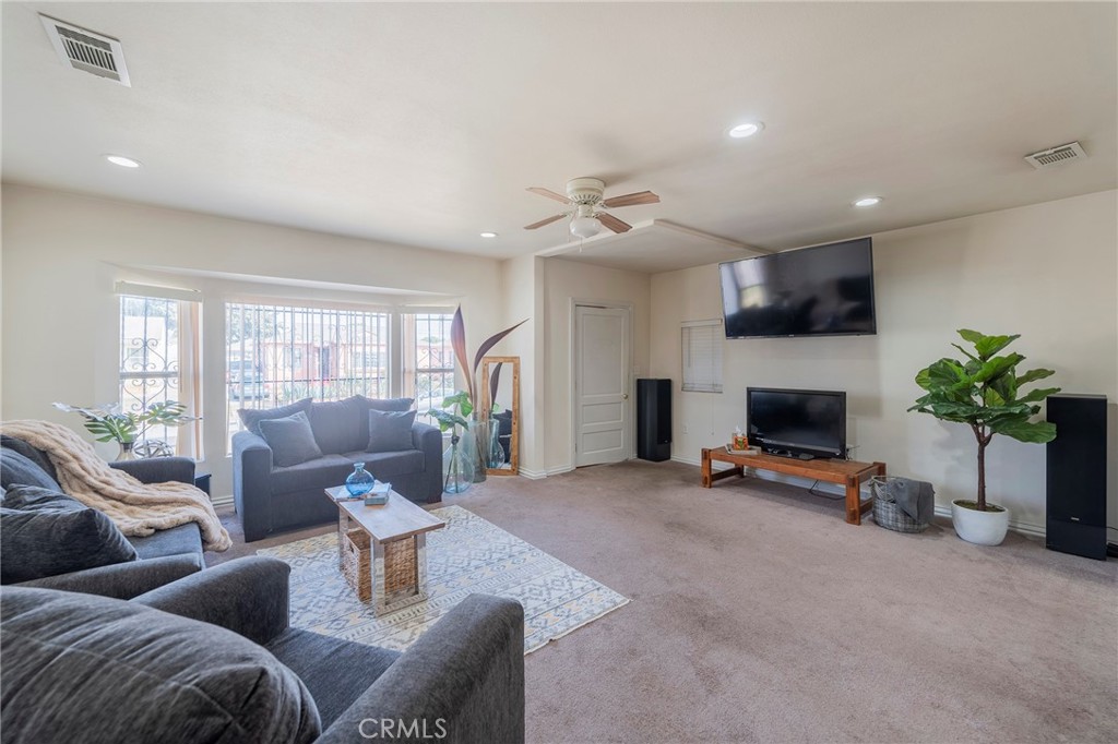 2734 West Caldwell Street Compton, CA 90220 - Photo 5 of 39 a living room with furniture gym equipment and a fireplace