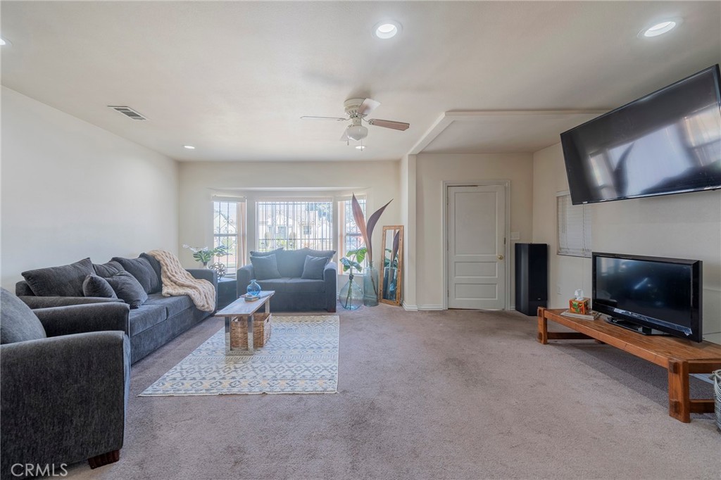 2734 West Caldwell Street Compton, CA 90220 - Photo 6 of 39 a living room with furniture a flat screen tv and a fireplace