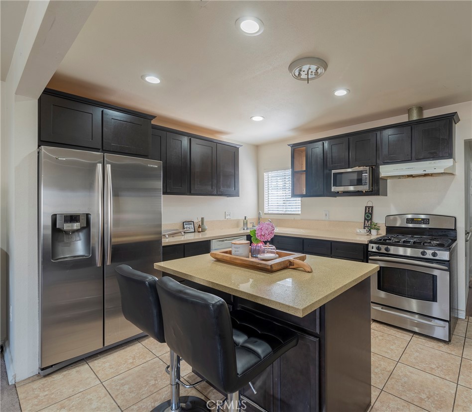 2734 West Caldwell Street Compton, CA 90220 - Photo 8 of 39 a kitchen with kitchen island a sink stove and refrigerator