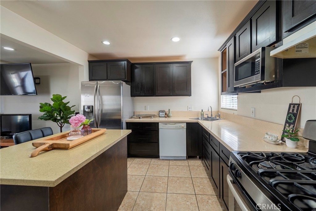 2734 West Caldwell Street Compton, CA 90220 - Photo 9 of 39 a kitchen with stainless steel appliances granite countertop a sink stove and refrigerator