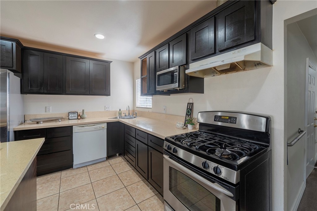 2734 West Caldwell Street Compton, CA 90220 - Photo 10 of 39 a kitchen with stainless steel appliances granite countertop a stove and a sink