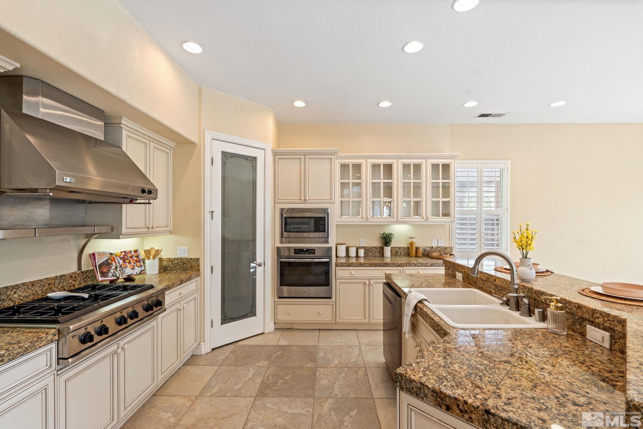 10035 Goler Wash Court Reno, NV 89521 - Photo 23 of 40 a kitchen with stainless steel appliances granite countertop a sink stove and refrigerator