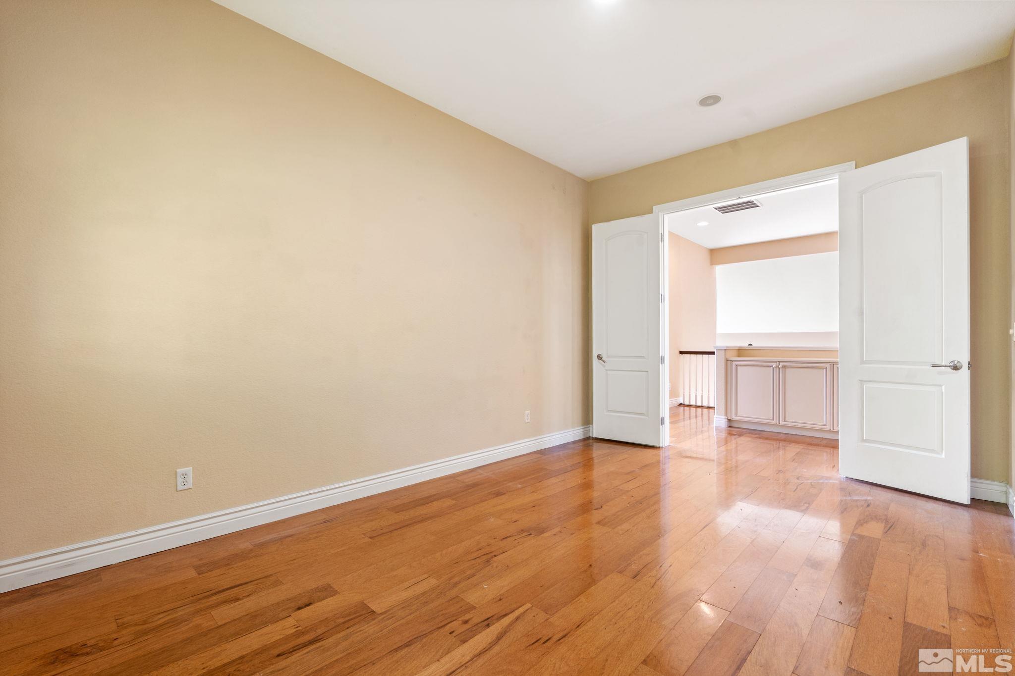10035 Goler Wash Court Reno, NV 89521 - Photo 25 of 40 a view of an empty room with wooden floor and a window