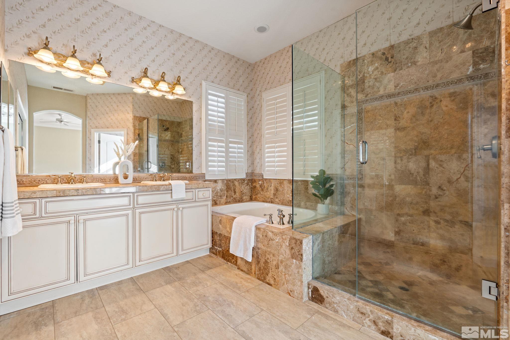 10035 Goler Wash Court Reno, NV 89521 - Photo 35 of 40 a bathroom with a double vanity sink a large mirror and a bathtub