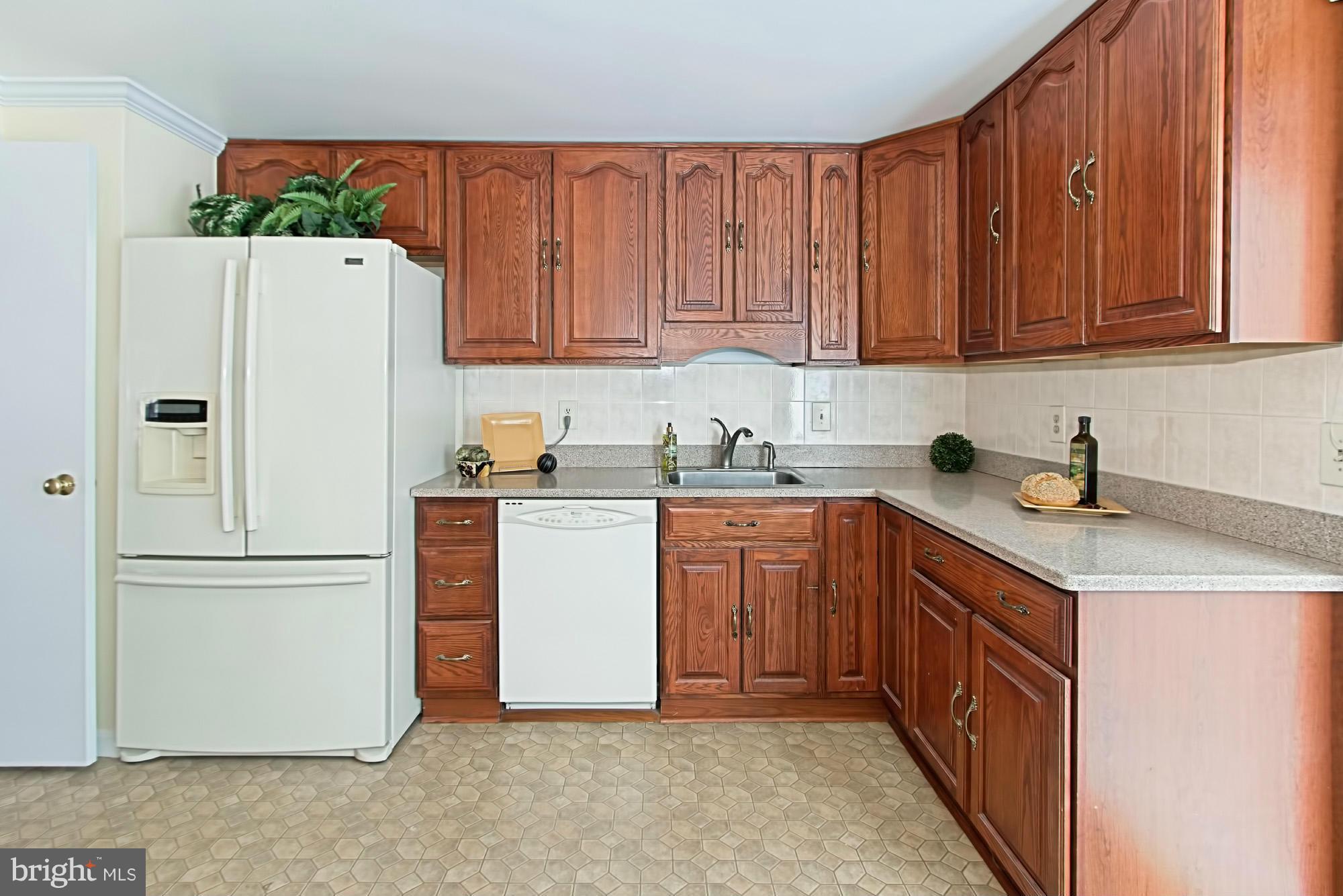 9505 Burning Branch Road Burke, VA 22015 - Photo 12 of 30 a kitchen with a refrigerator a stove a sink and cabinets