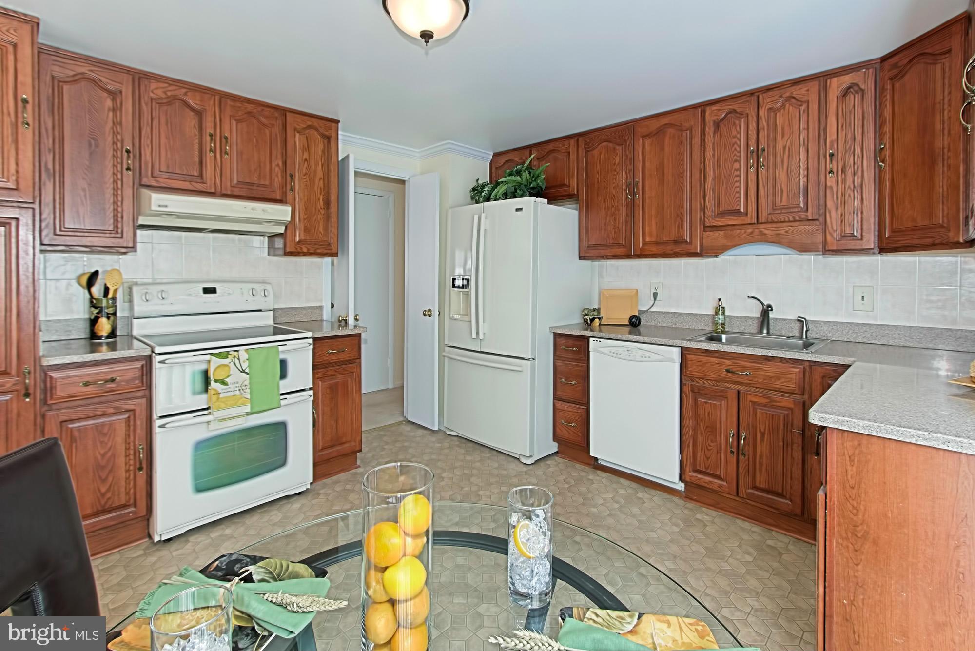 9505 Burning Branch Road Burke, VA 22015 - Photo 13 of 30 a kitchen with stainless steel appliances granite countertop a refrigerator sink and cabinets