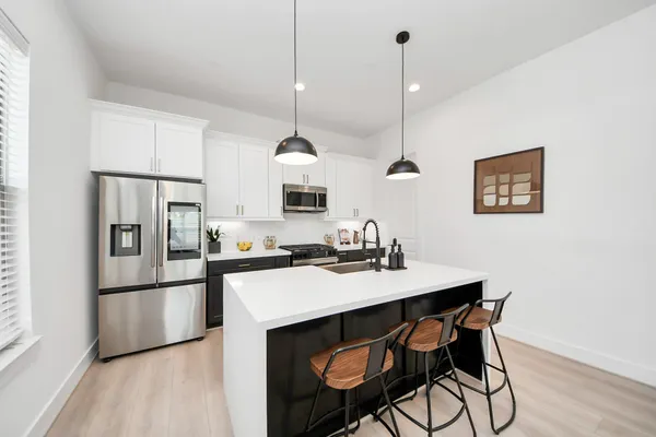 a kitchen with stainless steel appliances kitchen island granite countertop a kitchen island a stove a table and chairs