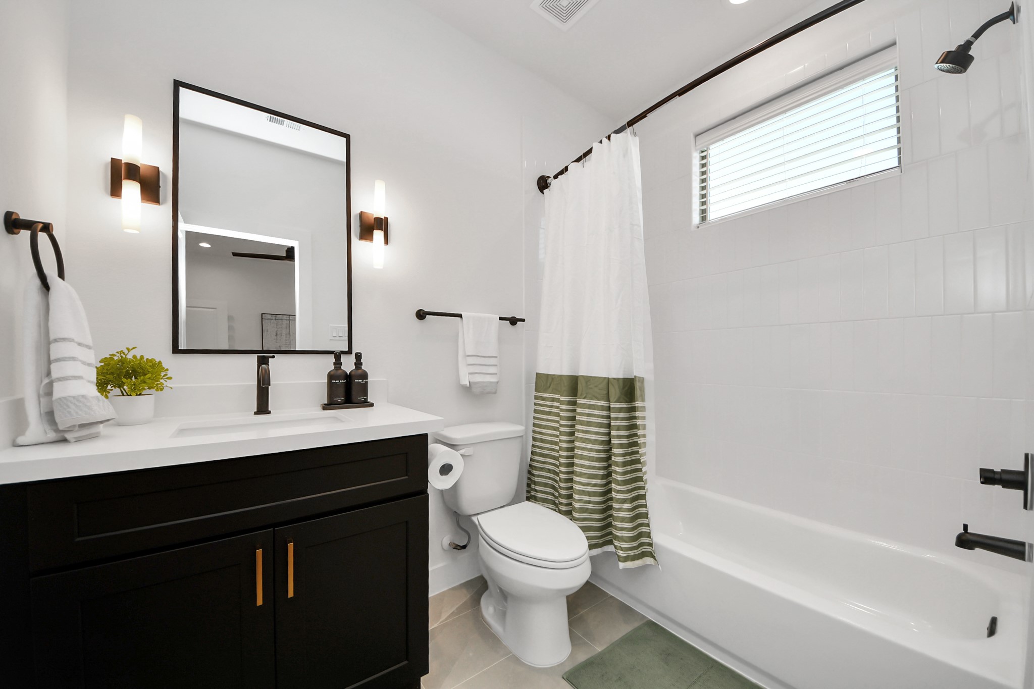 2524 Live Oak Street Houston, TX 77004 - Photo 36 of 50 a bathroom with a toilet a sink a mirror a bathtub and vanity